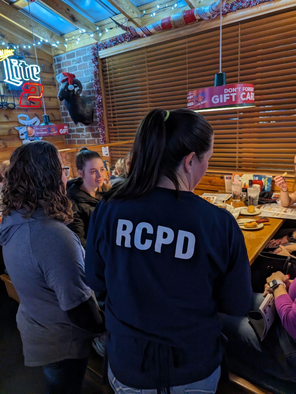 An officer and a special olympics kansas athlete work at Texas Roadhouse during the annual tip a cop